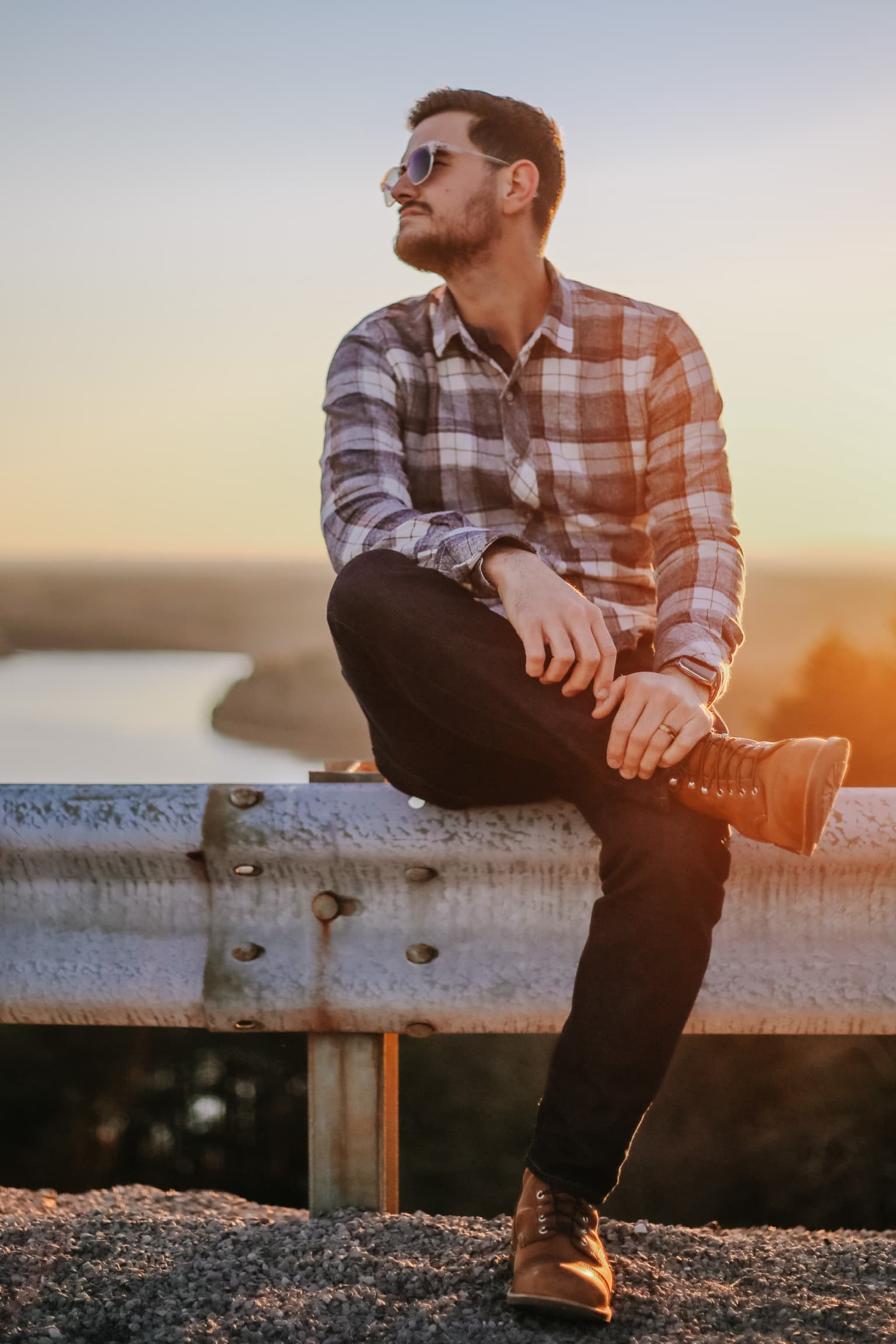 James Gurtner sitting on a guardrail at sunset overlooking the Tennessee River near Chattanooga.